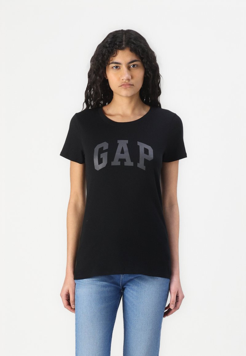 Zwarte katoenen T-shirt met "GAP" in vetgrijze letters over de borst. Klassieke ronde hals en korte mouwen. Casual pasvorm.