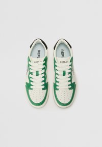 Hvite sneakers med grønne detaljer og svart hæl, med perforert tå, hvite snører og blå innersåle merket "REPLAY."