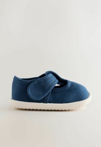 Chaussure bébé en tissu bleu foncé avec semelle blanche et fermeture à scratch sur un fond clair uni.