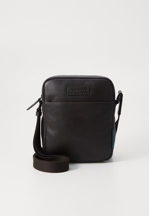 Braune Leder-Crossbody-Tasche mit rechteckiger Form, Reißverschluss, verstellbarem Stoffriemen und einem dezent eingeprägten Logo auf der Vorderseite.