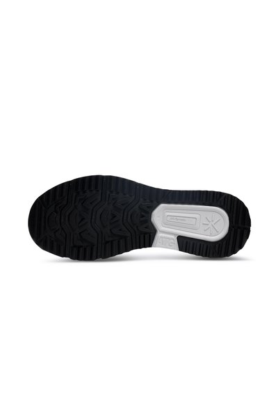 Black rubber shoe sole featuring a textured grip pattern, with a white midsole section labeled "ATG" for traction and stability.