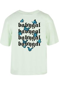 Mentolově zelené tričko s černým nápisem "babygal" a několika grafickými motivy modrých motýlů v různých pozicích na zadní straně. Krátké rukávy.