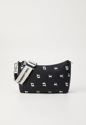 Sac à main noir texturé avec un petit motif graphique de visages blancs et une bandoulière beige détachable avec le texte "Karl Lagerfeld".