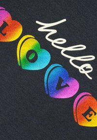 Il tessuto nero presenta forme di cuori colorate con un effetto sfumato, mostrando le parole "ciao" in bianco e "amore" in colori vivaci.