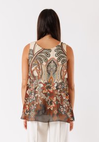 Top senza maniche con un design a motivo floreale in tonalità terrose, realizzato in tessuto leggero e con una silhouette fluida.