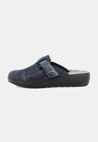 Zoccoli slip-on in tessuto blu con motivo testurizzato, fodera interna morbida e suola in gomma nera. Presenta una fascia laterale per una calzata sicura.
