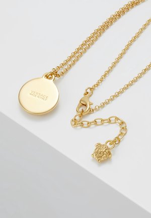 Złoty naszyjnik z łańcuszkiem i okrągłą zawieszką z wygrawerowanym napisem "Versace Made in Italy" oraz regulowanym zapięciem z ozdobą w kształcie głowy Meduzy.