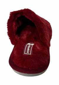 Zapatilla de felpa roja con textura suave, diseño de talón abierto y suela de goma. Cuenta con una etiqueta de logo en la plantilla.