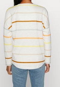 Randig långärmad tröja i vitt, med horisontella ränder i orange, gult, grått och beige. Mjuk textur med rundad nederkant.