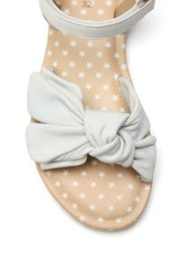 Sandal in pelle bianca con dettaglio a fiocco annodato. Suola interna tan con motivo a stelle bianche. Cinghia alla caviglia regolabile per una vestibilità ottimale. Taglia 32.