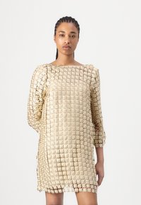Knee-length, krämfärgad klänning i genomskinligt tyg med blommönsterbroderi; har trekvartslånga ärmar och fyrkantig halsringning.