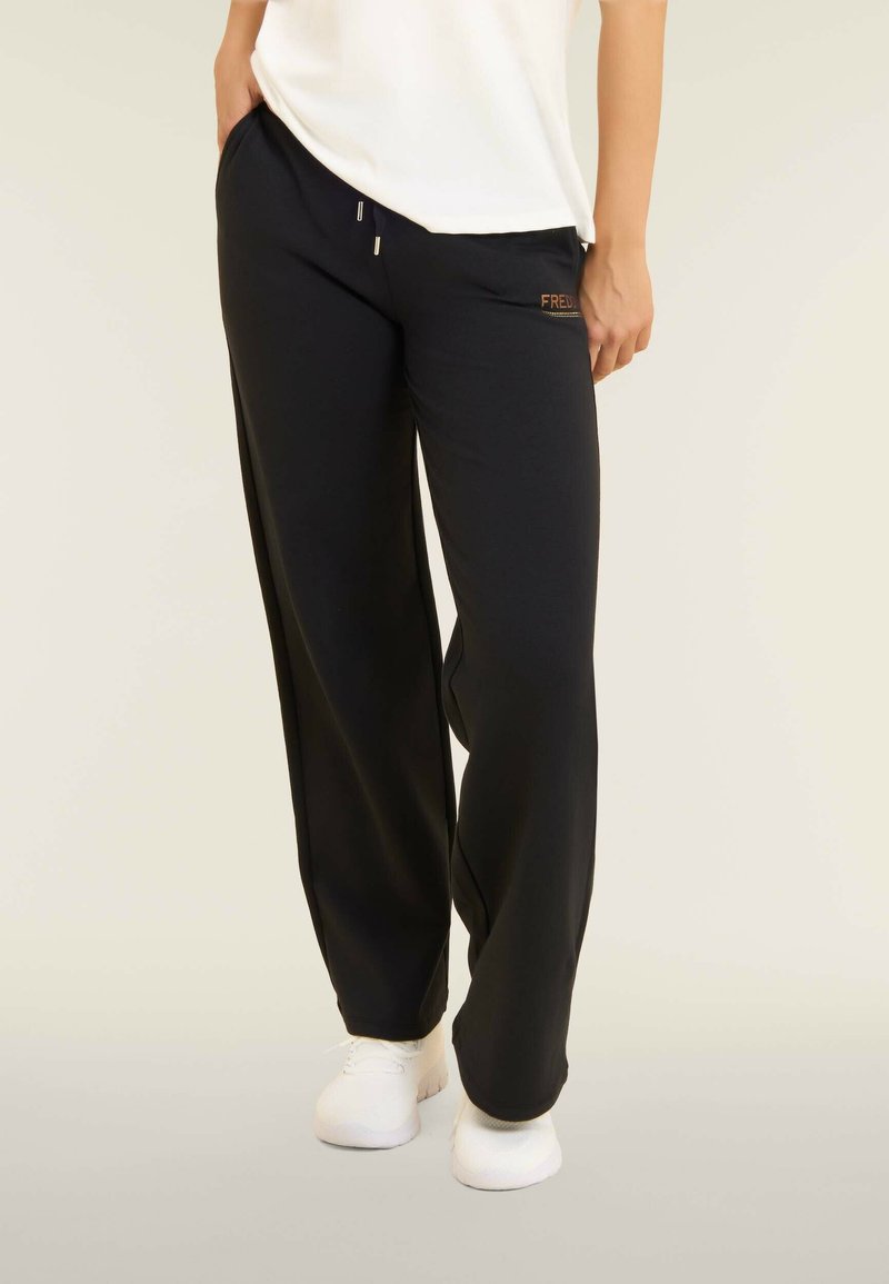 Pantaloni della tuta neri in un taglio rilassato, realizzati in tessuto morbido, con due tasche laterali e cerniere argentate, accentuati da un logo sull'anca.