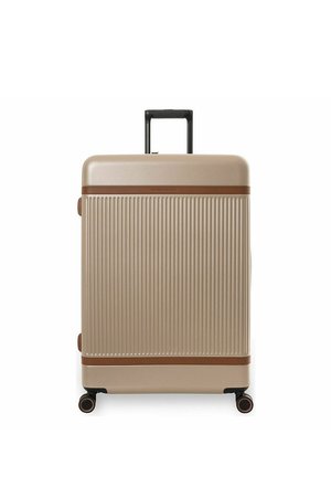 Beigenvärinen kovakuorinen matkalaukku pystysuorin urituksin, ruskeilla koristeilla, vedettävällä mustalla kahvalla ja neljällä mustalla pyörivällä pyörällä valkoisella taustalla.