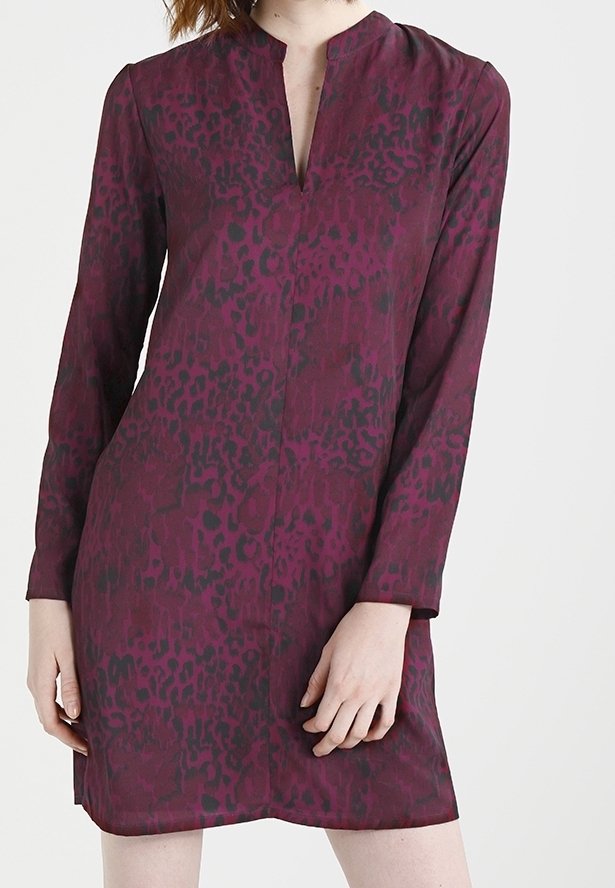 Femme portant une robe à manches longues, longueur genoux, avec un motif léopard violet foncé et noir et un décolleté en V.