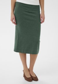 Zelená midi sukňa z bavlneného materiálu s hladkou textúrou a priamym strihom. Má priliehavý pás a jemné švové detaily.