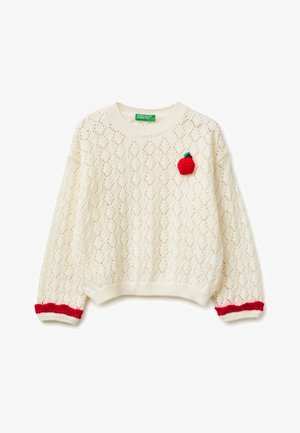 Pull en maille crème avec un motif en losange, application de pomme rouge sur la poitrine, et poignets rouges à volants sur les manches longues.