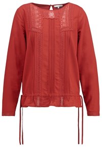 Blouse rouge à manches longues avec des dentelles, design à pinces sur le devant et liens ajustables à l'ourlet pour un ajustement froncé.