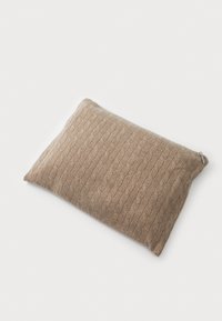Brown textured pillow with a cable-knit pattern, rectangular shape, featuring a zipper detail on one side. Soft fabric surface.