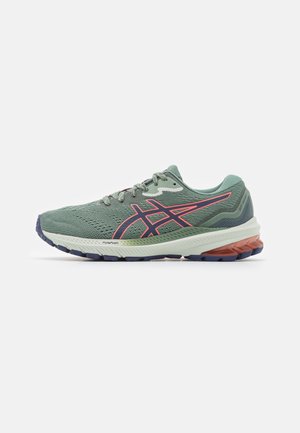 Chaussure de course verte et rose avec semelle blanche et orange amortie, empeigne en mesh respirant et semelle extérieure à motif, vue de côté.