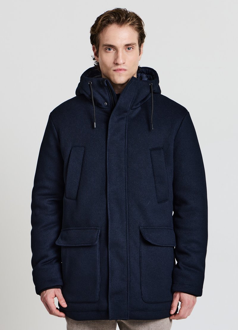 Parka imbottito blu navy con finitura testurizzata, ampie tasche frontali, cappuccio regolabile e chiusura con doppia cerniera.
