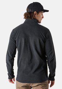 Svart fleece-pullover med ståkrage och långa ärmar. Slät textur med en kontrasterande fåll över den övre ryggen.