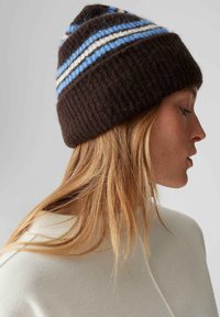 Knitted brown beanie with blue and white horizontal stripes. Features a ribbed texture and a fitted design, suitable for cold weather.