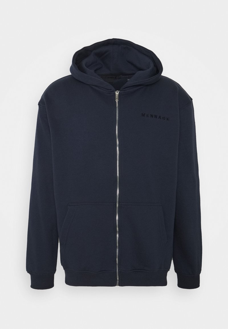 Haut à capuche zippé bleu marine en tissu doux, avec une poche frontale, des poignets côtelés et un logo minimaliste sur la poitrine. Texture lisse.