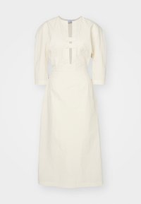 Rochie crem, până la genunchi, cu un decolteu modest, mâneci trei sferturi și două accente cu nasturi în față. Material cu textură, croi structurat.