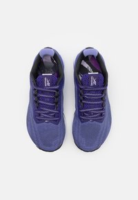 Une paire de chaussures de course Reebok violettes et noires avec des lacets à motifs, une tige en maille et un collier rembourré, vue du dessus sur fond blanc.