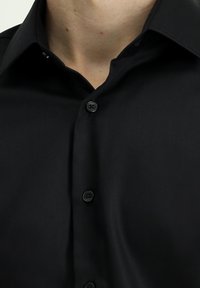 Zwart overhemd met klassieke kraag, voorzien van een gladde textuur, voorbies en vier zwarte knopen. Geen zichtbare patronen of accenten.