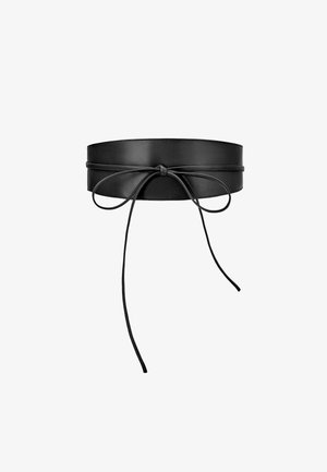 Large ceinture en cuir noir nouée en nœud avec de longues lanières fines pendantes sur fond blanc.