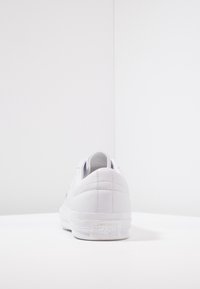 Baskets en cuir blanc avec une texture lisse, un bout arrondi et un design minimaliste. Présentent un logo sur le talon et un col rembourré.