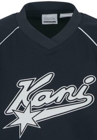 Granatowa koszulka sportowa z dekoltem w kształcie V, z białymi literami napisanymi "Kani" oraz grafiką gwiazdy. Wykonana z teksturowanej tkaniny, zaprojektowana z myślą o komforcie.