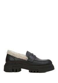 Zwarte leren loafers met een fluffy crèmevoering, voorzien van een brede band en een dikke zwarte rubberen zool met geribbeld patroon.