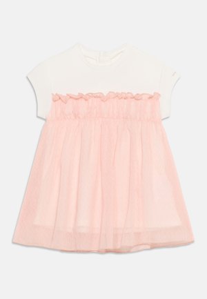 Kortermet hvit topp med påsydd myk, rosa tyllkjole med volangtopp og lagdelt skjørt for barn.