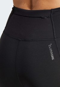 Black activewear leggings with a smooth texture, featuring a flat waistband and stitched seams. Includes "climacool" branding on the side.