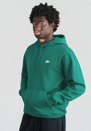 Žalia džemperis su gobtuvu ir priekinė kišene, ant krūtinės mažas baltas Nike logotipas. Švelnios audinio tekstūros, įprasto silueto.