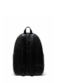 Sac à dos noir de forme arrondie, fabriqué en matériau lisse. Comprend des bretelles réglables, une poignée supérieure et un design minimaliste sans quincaillerie visible.