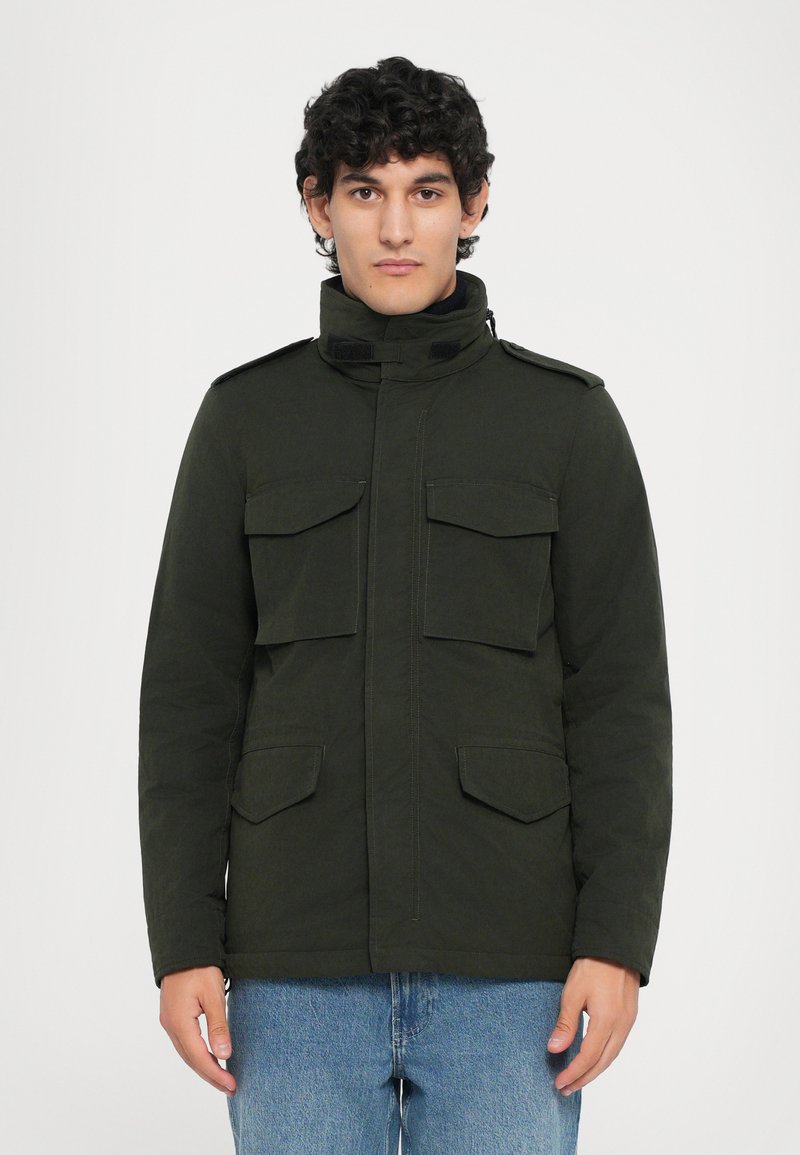 Dunkelgrüne, isolierte Jacke mit hohem Kragen, zwei Brusttaschen und zwei unteren Taschen. Verfügt über einen Reißverschluss und einen Klettverschluss. Freizeitliches Design.