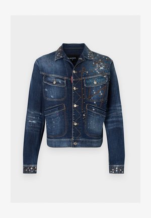 Veste en denim bleu foncé avec quatre poches sur le devant, boutons en argent et clous décoratifs en métal ainsi que des éclaboussures de peinture sur la poitrine et les poignets.