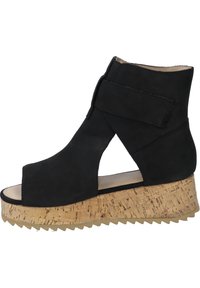 Black suede ankle boot with a cork wedge sole. Open toe design features a side cutout and a Velcro strap on the upper for secure fit.
