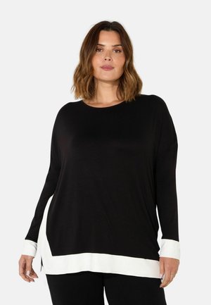 Schwarzes Langarmshirt mit rundem Halsausschnitt und weißen Saum-Akzenten. Weicher Stoff und lockere Passform mit seitlichen Schlitzen. Klassisches Farbblockdesign.