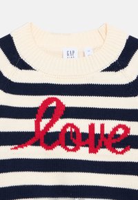 Sweter w paski granatowo-kremowy z czerwonym napisem "Love", z prążkowanym okrągłym dekoltem i teksturowaną tkaniną. Etykieta marki: GAP Kids.