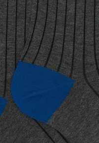 Calze grigie a coste con sottili strisce nere, dotate di un tallone e una punta blu. Il materiale sembra morbido con una texture liscia.