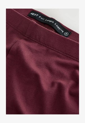 Leggings lunghi color bordeaux realizzati in un tessuto liscio e elastico con cuciture piatte. L'etichetta riporta "NEXT Leggings Lunghi". Taglia 8.
