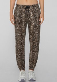 Leopardenmuster-Jogginghose mit verstellbarem Bund, schmal zulaufendem Bein und elastischen Bündchen; aus leichtem Stoff mit glatter Textur gefertigt.