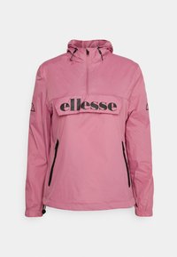 Rosa vindjacka med halvdragkedja framtill, svart logoband över bröstet, justerbar huva och sidofickor med dragkedja. Slät textur.