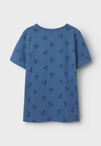 Blå kortærmet T-shirt lavet af bomuld. Har et gentaget mønster med sorte kaniner. Rund hals og lige kant. Blød tekstur.