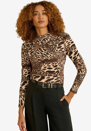 Langärmeliges Oberteil mit Leopardenmuster und Stehkragen, aus einem glatten Stoff gefertigt, kombiniert mit hoch taillierten schwarzen Hosen und einem Gürtel.