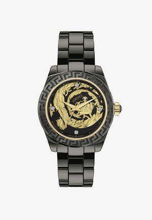 Orologio in metallo nero con un quadrante dorato ornato di un motivo a foglia, accenti di diamante e un motivo a chiave greca sulla lunetta. Prodotto in Svizzera.